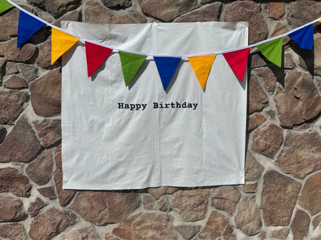 Finished product of the hand-painted linen sign with fabric garland